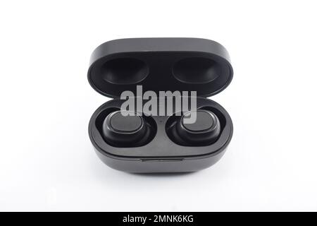 Wireless earphone bluetooth voice control with charger isolated on white background. Wireless earphones with its case opened. Stock Photo