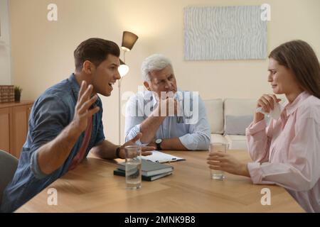 Professional psychotherapist working with emotional couple in office Stock Photo