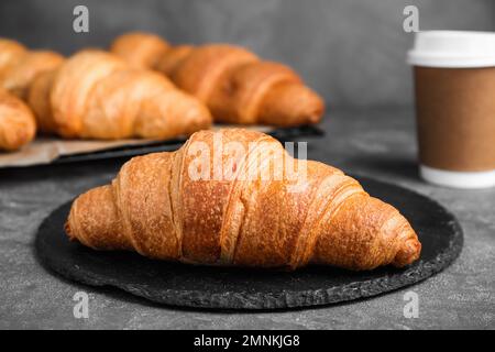 Tasty fresh crispy croissants on grey table Stock Photo