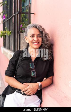 Confident gray haired senior woman in convinced attitude crossing arms Stock Photo