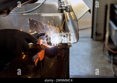 Worker working welding metal with sparkle using welding machine semi automatic argon gas shielded welding Stock Photo