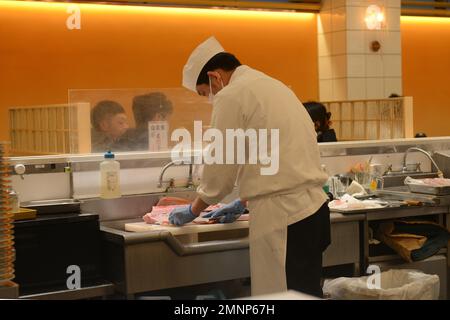 Sushi chef filleting a fresh Tuna fish at the Kaiten Sushi restaurant in Tokyo, Japan. Stock Photo