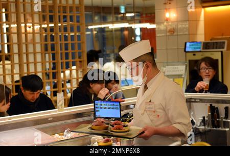 Sitting inside the Kaiten Sushi restaurant in Jingumae, Tokyo, Japan ...