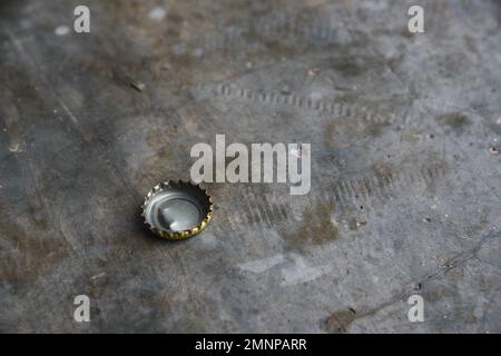Bottle cap on a grey stone surface with copy space Stock Photo