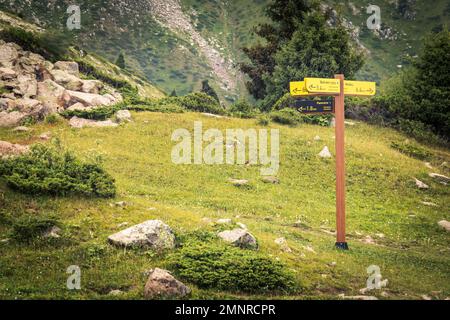 Signpost for tourists with directions on a hiking trail in the mountains of Almaty. Development of the tourism infrastructure of domestic tourism in Stock Photo