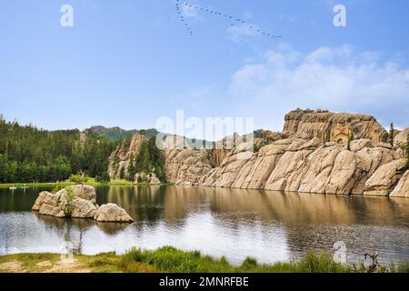 Spires around Sylvan Lake with hills and trees in the distnace in a sunny summer South Dakota landscape Stock Photo