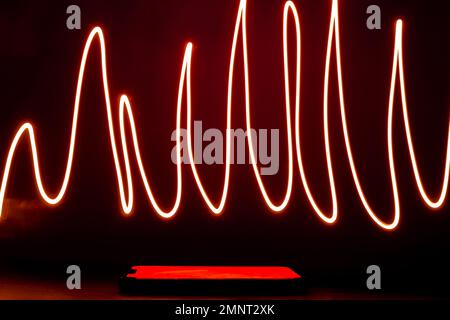 Abstract red lines drew by using long exposure of camera and flash light shape of graphic. Investing in the online puppet market. Network internet mobile wireless business concept  Stock Photo