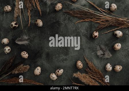 Frame with Easter eggs and feathers on dark. Flat lay, Top view. Easter holiday concept. Stock Photo