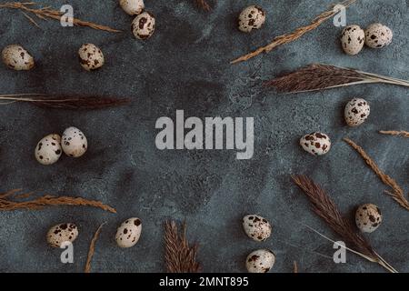 Frame with Easter eggs and feathers on dark. Flat lay, Top view. Easter holiday concept. Stock Photo
