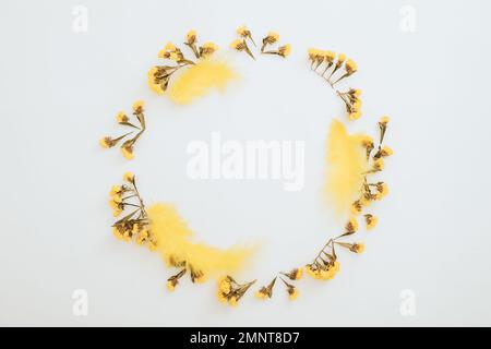 Frame made of eggs and yellow flowers on white background. Flat lay, top view. Easter holiday Stock Photo