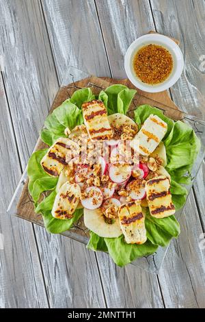 Apple salad, lettuce and halloumi cheese on wooden Stock Photo