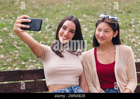 two young women smiling happy while taking a photo Stock Photo