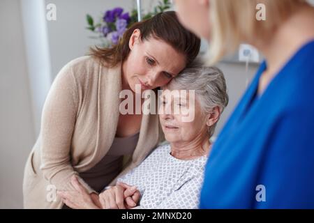 Well get through this. A daughter consoling her mother in the hospital after hearing from the nurse. Stock Photo