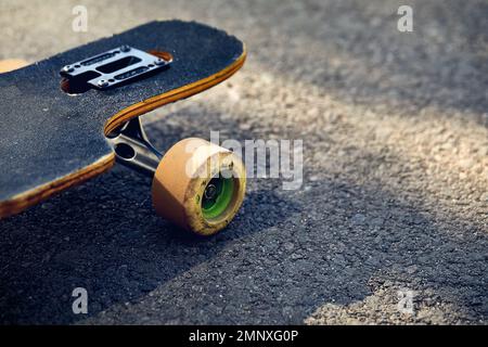 Skate board longboard at mountain asphalt road close up shot at of tail with wheels detail Stock Photo