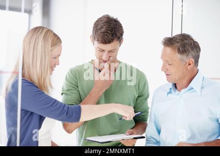 They work better as a team. Three work colleagues discussing something work related. Stock Photo