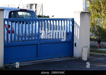 sliding gray high gate metal grey home fence on suburb house Stock Photo