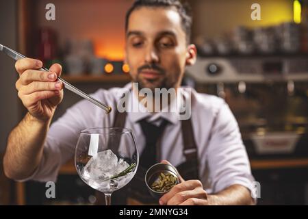Expert barman is making cocktail at night club Stock Photo