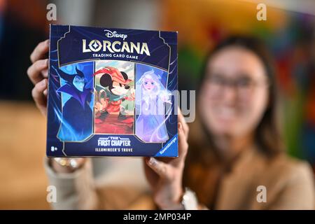 Ravensburg, Germany. 26th Jan, 2023. An employee of the game manufacturer  Ravensburger AG holds the new trading card game Disney Lorcana Trading Card  Game, The First Chapter. The trading card game is