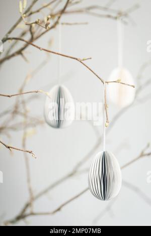 Easter paper eggs hanging on branches. Scandinavian-style Easter decorations. Stock Photo