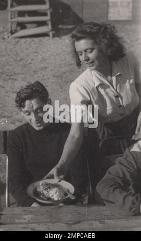 vintage moment / vintage funny moment / vintage photograph / power of the moment / magic moments / vintage eating / eating / vintage food / one lady possibly a waitress is serving food to her customer or may be he is her husband. Nice big portion food. Enjoy. 1930s photo. Stock Photo