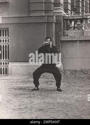 vintage moment / vintage funny moment / vintage photograph / power of the moment / magic moments /performance / vintage / super rare vintage photo about a photographer with his camera in an action pose. Stock Photo