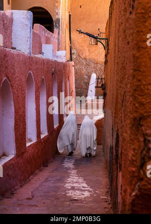 Mozabite women in white haïk in the streets of Ksar El Atteuf, North Africa, Ghardaia, Algeria Stock Photo