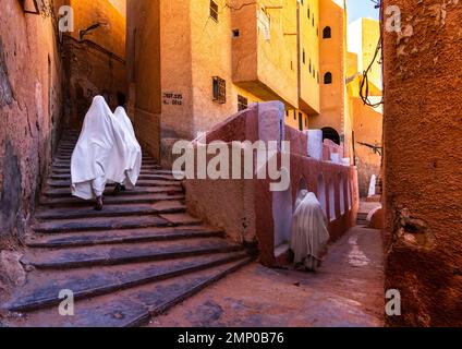 Mozabite women in white haïk in the streets of Ksar El Atteuf, North Africa, Ghardaia, Algeria Stock Photo