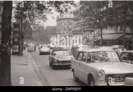 vintage moment / vintage funny moment / vintage photograph / power of the moment / magic moments / vintage street view possibly from France at the 1960's- there are lots of french cars bicycle and tuc tuc. it was  a busy day possibly a monday :) Stock Photo