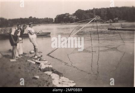 vintage moment / vintage funny moment / vintage photograph / power of the moment / magic moments / vintage fishermen are in action / 1920s fishing technique Stock Photo