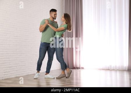 Lovely young couple dancing together at home Stock Photo
