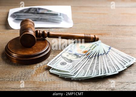 Dollar bills and gavel on wooden table. Bribe concept Stock Photo