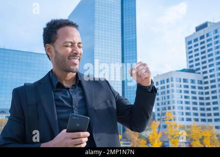 Cheerful businessman in suit raised arms smiling happy celebrates success. Happy real people. Stock Photo