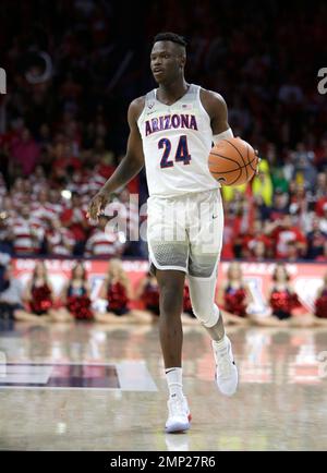 Arizona guard Emmanuel Akot (24) shoots while defended by Washington