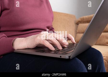 Mature female hands typing text on keyboard. Elderly senior woman using or working on laptop. Old people with technology concept idea. Writing email. Stock Photo