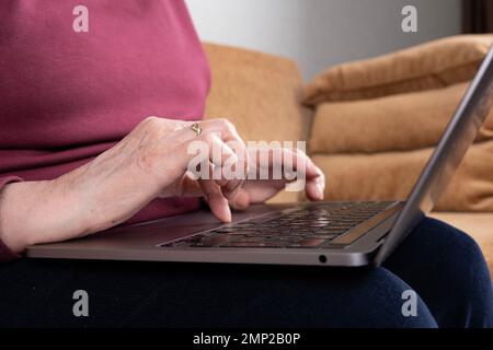 Elderly woman hands using modern laptop. Old caucasian lady finger touching notebook. Businesswoman, remote work, writing email, online, copy space Stock Photo