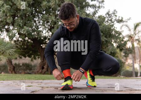 Young athlete tying the laces of her tennis s Stock Photo