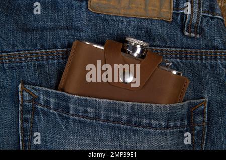 Hip flask in denim blue jeans pocket Stock Photo