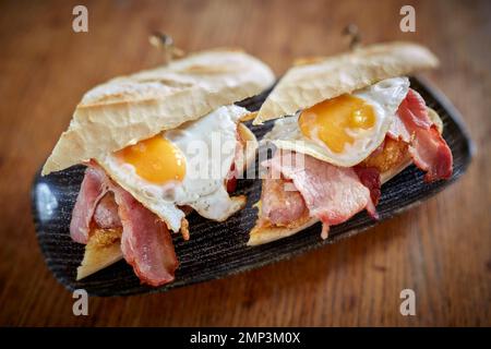 Breakfast fry up brunch gastro pub full english beans bap tomato black pudding potato hash brown scrambled egg bacon tasty food meal classic Stock Photo