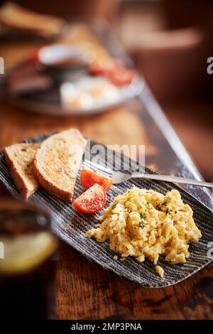 Breakfast fry up brunch gastro pub full english beans bap tomato black pudding potato hash brown scrambled egg bacon tasty food meal classic Stock Photo