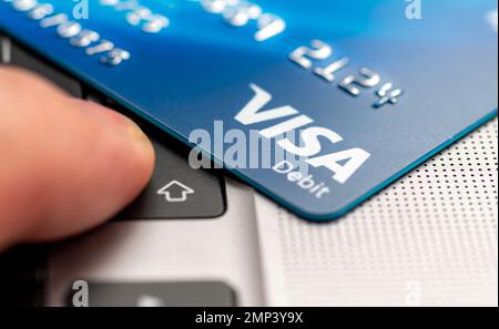 London. UK- 01.29.2023. A Visa Debit card on a laptop computer with a person pressing the enter button. Stock Photo