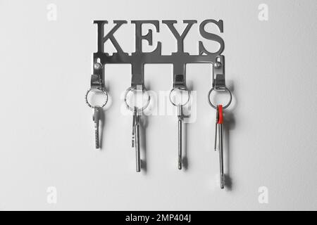 Key holder with keys hanging on the wall Stock Photo - Alamy