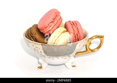 Multi colored macarons in vintage tea cup Stock Photo