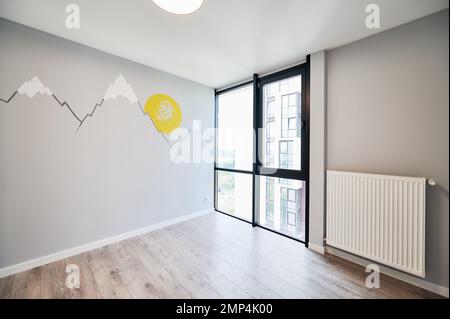 New renovated bedroom with parquet floor and painted illustration on white wall. Modern children room interior after renovation. Stock Photo