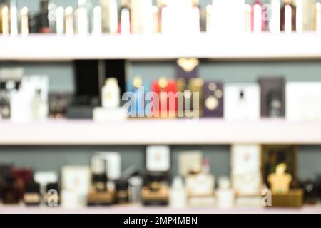 Blurred view of shelves with perfume bottles in shop Stock Photo