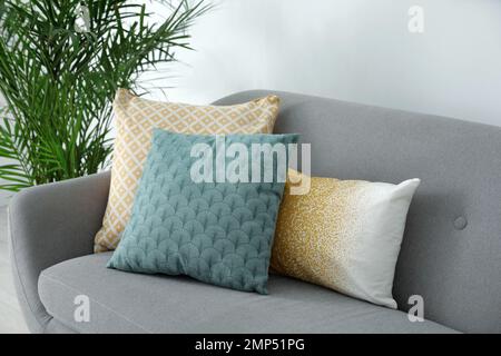 Different soft pillows on sofa in living room Stock Photo