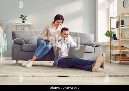 Happy couple having video chat using laptop computer at home Stock Photo