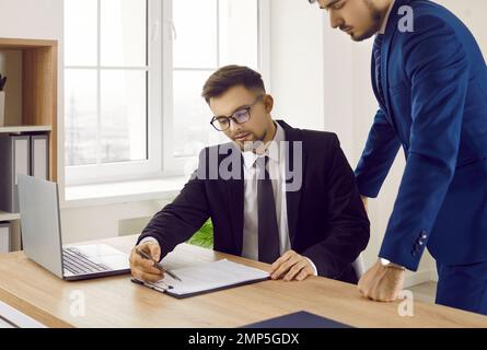Two young business people working with a business contract agreement in the office Stock Photo