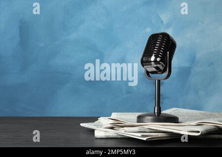 Newspapers and vintage microphone on table, space for text. Journalist's work Stock Photo