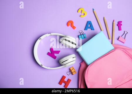 Flat lay composition with book and headphones on lilac background Stock Photo