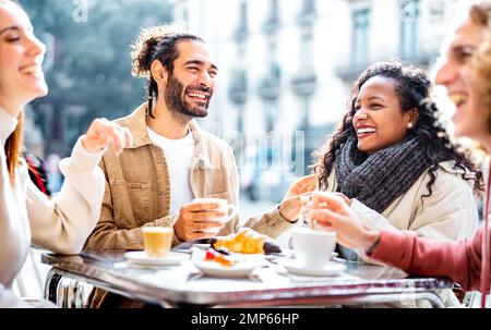 Young couples drinking cappuccino at coffee bar patio - Friends talking and having fun together at sidewalk cafeteria - Food life style concept Stock Photo